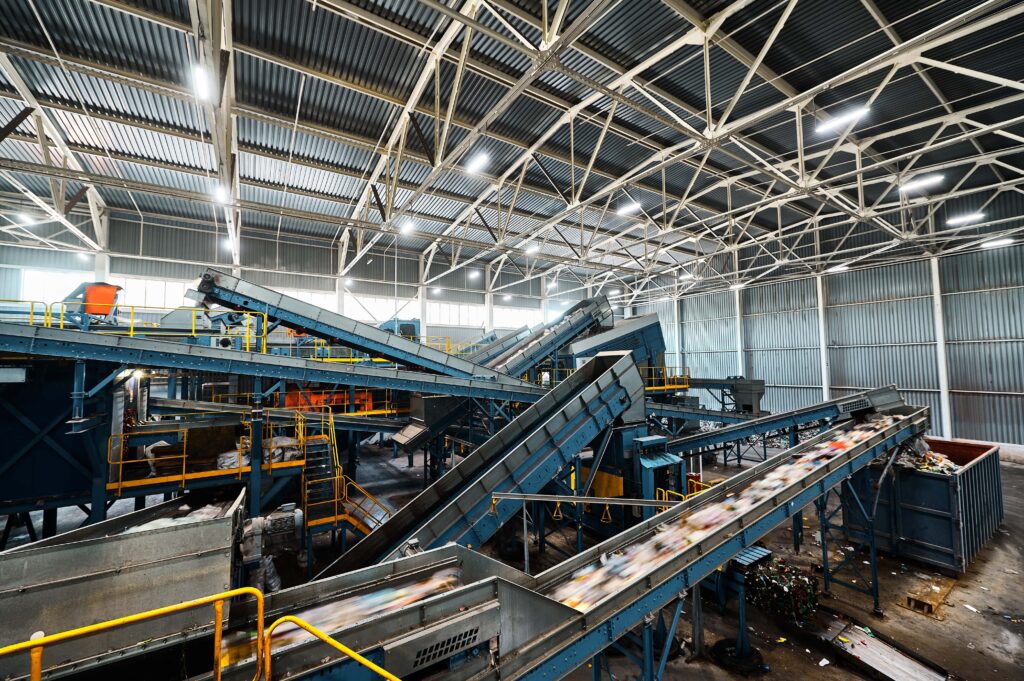 Conveyor belts moving recycled materials in a warehouse.