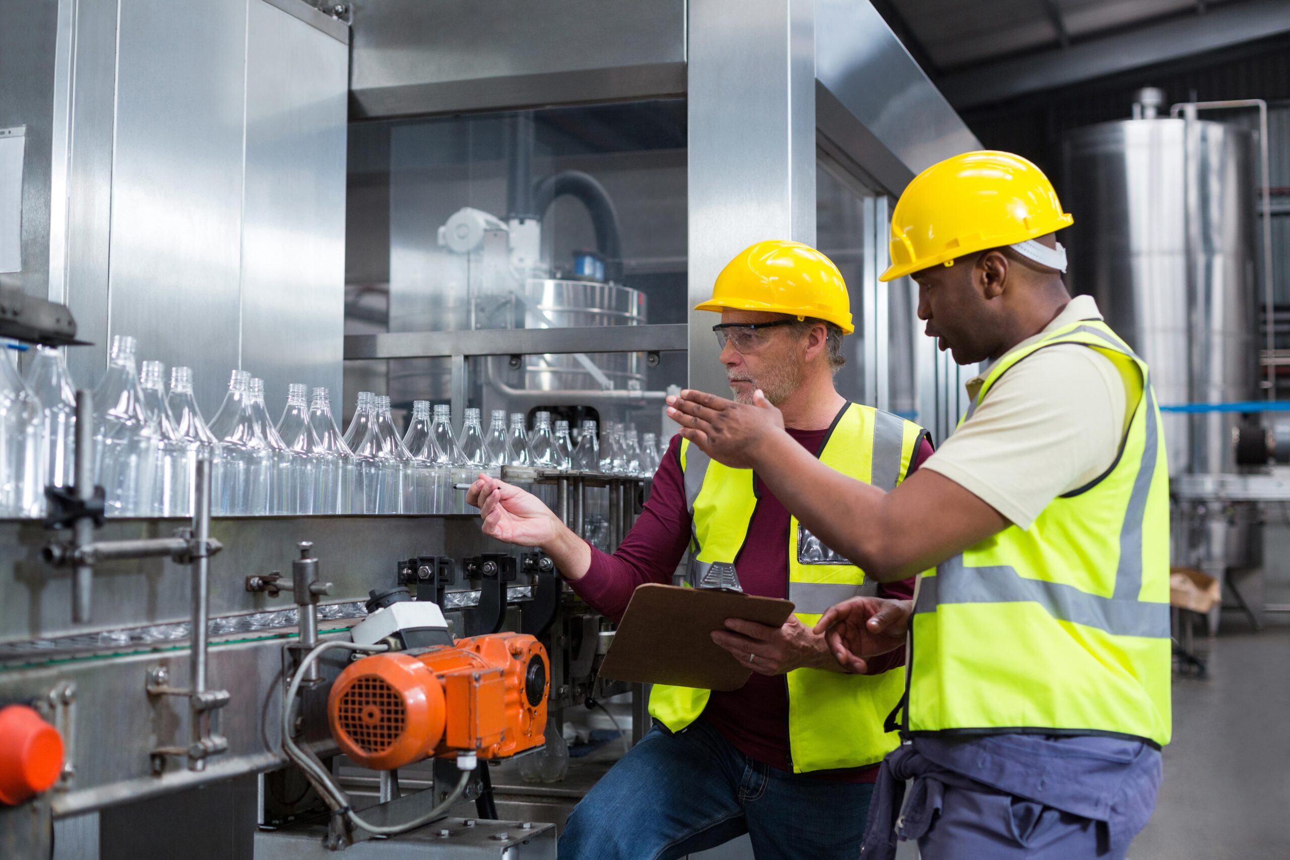Two engineers analyzing a conveyor belt in a factory.