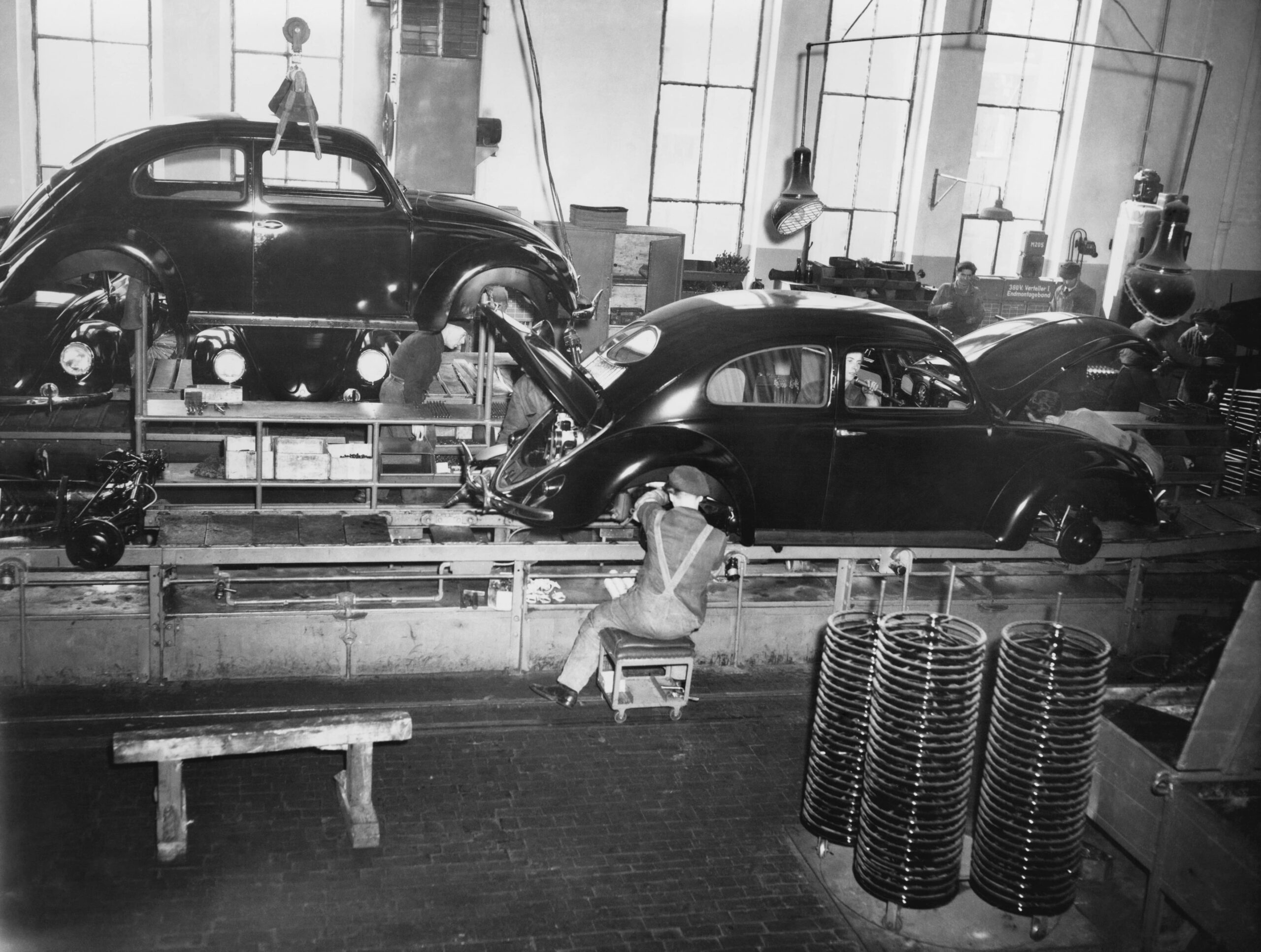 Cars on a conveyor belt assembly line.